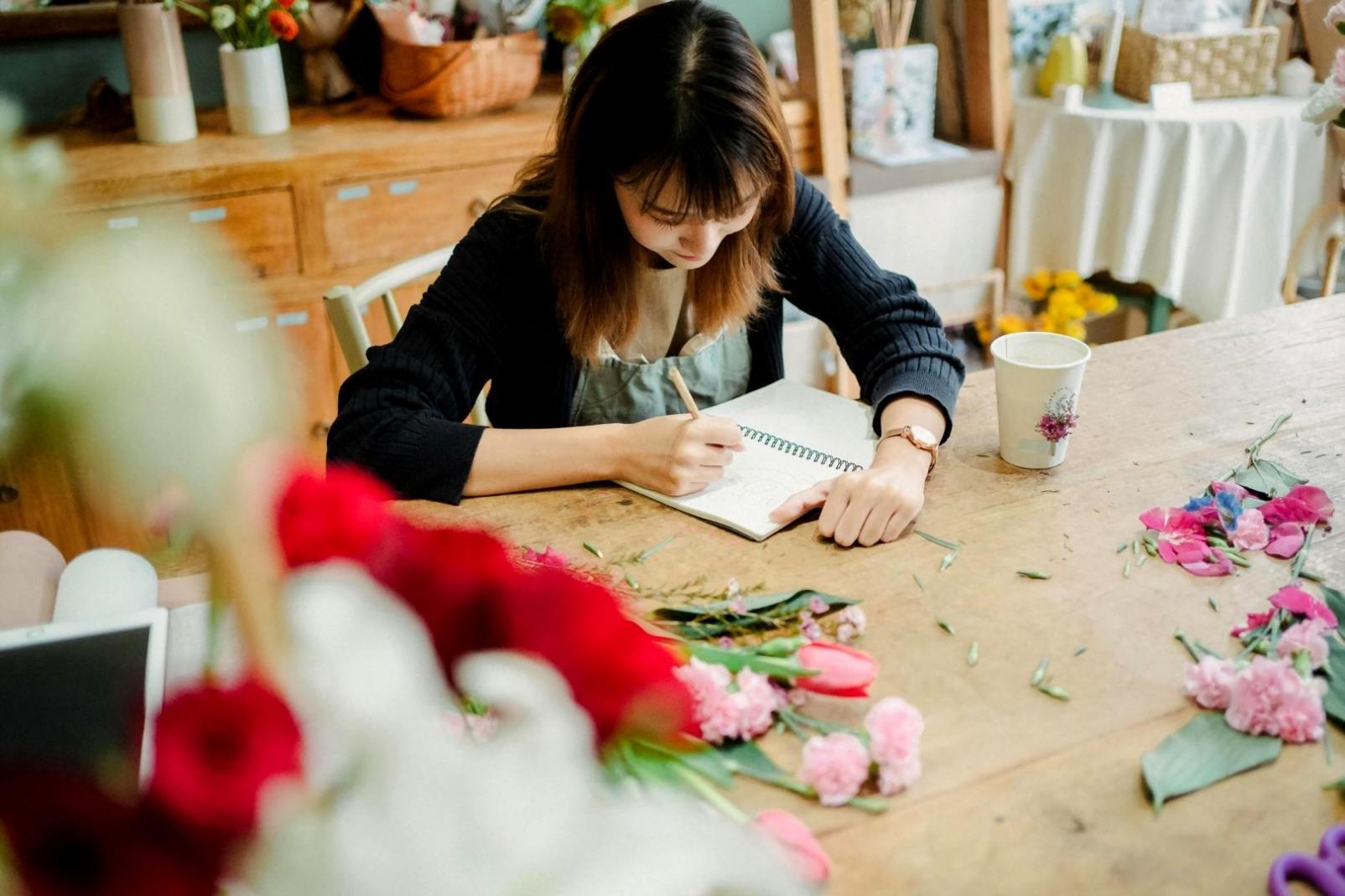 Close-up of hands arranging fresh flowers during training session